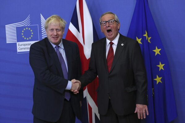 British Prime Minister Boris Johnson shakes hands with European Commission President Jean-Claude Juncker during a press point at EU headquarters in Brussels, Thursday, Oct. 17, 2019. Britain and the European Union reached a new tentative Brexit deal on Thursday, hoping to finally escape the acrimony, divisions and frustration of their three-year divorce battle. (AP Photo/Francisco Seco)