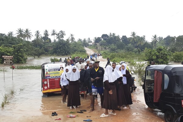 Schoolchildren stranded on a damaged River Zingiziwa bridge in Dar Esalaam, Tanzania Thursday, April 25, 2024. Flooding in Tanzania caused by weeks of heavy rain has killed 155 people and affected more than 200,000 others, the prime minister said Thursday. (AP Photo)