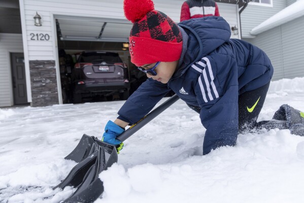 Adyaan Islam, 5, helps his family shovel the driveway in Meridian, Idaho, Sunday, Jan. 14, 2024. At the Boise Airport 6.8 inches of snow was measured from Saturday afternoon's winter storm. (Sarah A. Miller/Idaho Statesman via AP)