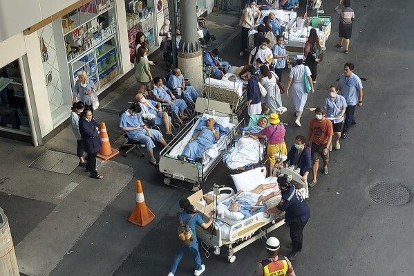 Patients are evacuated outdoors at a hospital after a 7.7 magnitude earthquake in Bangkok, Thailand, Friday, March 28, 2025. (AP Photo/Tadchakorn Kitchaiphon)