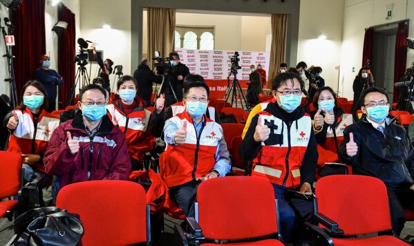 Doctors and members of the Chinese Red Cross pose for a photo prior to a press conference in Rome, Friday, March 13, 2020. A charter plane carrying members of a medical team and several tons of medical supplies from China arrived in Rome late Thursday to assist Italy in fighting the coronavirus outbreak. For most people, the new coronavirus causes only mild or moderate symptoms. For some it can cause more severe illness. (Alfredo Falcone/LaPresse via AP)