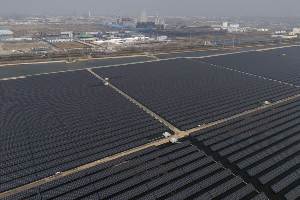A solar farm operates near a chemical plant on the outskirts of Weifang in eastern China's Shandong province on March 22, 2024. (AP Photo/Ng Han Guan, File)