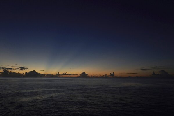 
              The last rays of sunlight cross the sky after sunset while at sea in the waters off the Seychelles, Monday April 1, 2019. For more than a month researchers from Nekton, a British-led scientific research charity, have been using submersibles to dive deep below the waves to document changes taking place beneath the waves that could affect billions of people in the surrounding region over the coming decades. (AP Photo/David Keyton)
            