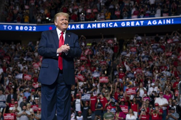 FIL E- In this June 20, 2020, file photo President Donald Trump arrives on stage to speak at a campaign rally at the BOK Center in Tulsa, Okla. After months of insisting that the Republican National Convention go off as scheduled despite the coronavirus pandemic, Trump is slowly coming to accept that the event will not be the four-night informercial for his re-election that he had anticipated. (AP Photo/Evan Vucci, File)