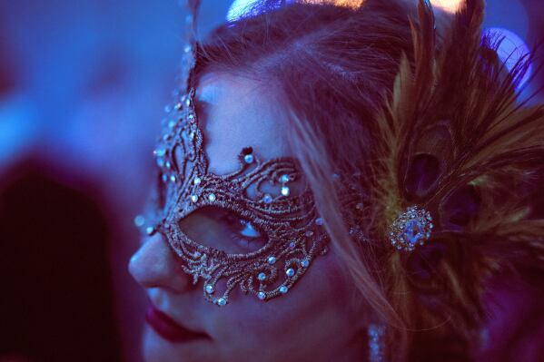 A costumed guest attends the Great Masked Ball in the Orangerie of the Versailles castle, outside Paris, Sunday, June 22, 2025. (AP Photo/Christophe Ena)