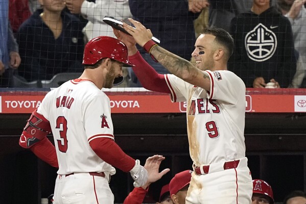 Los Angeles Angels' Zach Neto, right, places an illuminated halo on Taylor Ward after Ward hit a solo home run during the seventh inning of a baseball game against the St. Louis Cardinals Wednesday, May 15, 2024, in Anaheim, Calif. (Ǻ Photo/Mark J. Terrill)