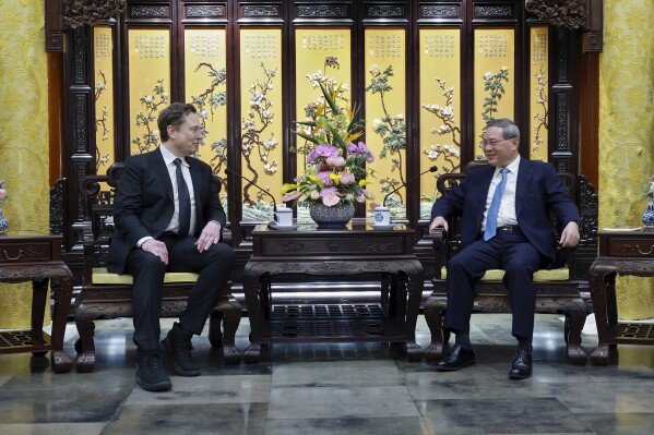 REMOVES FOUNDER FROM ELON MUSK TITLE In this photo released by Xinhua News Agency, visiting Tesla CEO Elon Musk, left, meets with Chinese Premier Li Qiang in Beijing, Sunday, April 28, 2024. Musk met with a top government leader in the Chinese capital Sunday, just as the nation's carmakers are showing off their latest electric vehicle models at the Beijing auto show. (Wang Ye/Xinhua via AP)
