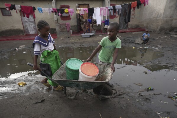 Children fetch water using a wheelbarrow in Lilanda township in Lusaka, Zambia, Saturday March 9, 2024. (AP Photo/Tsvangirayi Mukwazhi)