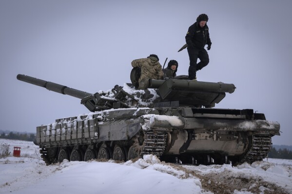 FILE - Ukrainian soldiers practice on a tank during military training, in Ukraine, Wednesday, Dec. 6, 2023. A gloomy mood hangs over Ukraine’s soldiers nearly two years after Russia invaded their country. Ukrainian soldiers remain fiercely determined to win, despite a disappointing counteroffensive this summer and signs of wavering financial support from allies. (AP Photo/Efrem Lukatsky, File)