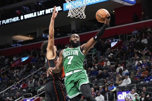 Boston Celtics guard Jaylen Brown (7) drives on Detroit Pistons guard Cade Cunningham (2) in the first half of an NBA basketball game in Detroit, Friday, March 22, 2024. (AP Photo/Paul Sancya)