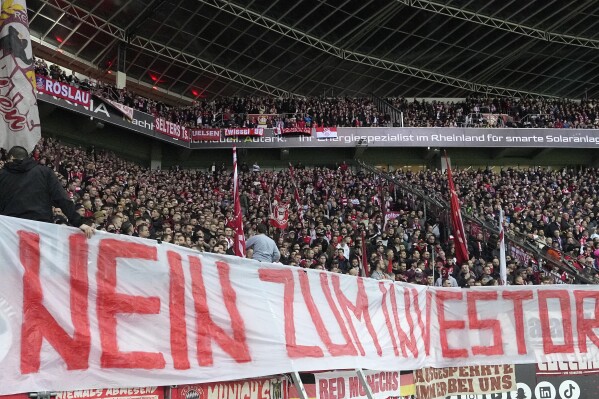 Bayern supporters protest with a banner reading "No to investors!" during the German Bundesliga soccer match between Bayer Leverkusen and Bayern Munich in Leverkusen, Germany, Saturday Feb. 10, 2024. (APPhoto/Martin Meissner)