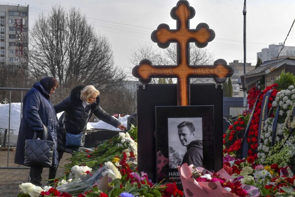 ADDS NAME OF PERSON NAVALNY'S MOTHER-IN-LAW - Russian opposition leader Alexei Navalny's mother, Lyudmila Navalnaya, left, and his mother-in-law Alla Abrosimova visit the grave of Alexei Navalny after his yesterday funeral at the Borisovskoye Cemetery, in Moscow, Russia, on Saturday, March 2, 2024. Navalny, who was President Vladimir Putin's fiercest foe, was buried after a funeral that drew thousands of mourners amid a heavy police presence. (AP Photo)