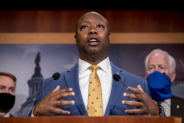 FILE - In this June 17, 2020, file photo, Sen. Tim Scott, R-S.C., accompanied by Republican senators speaks at a news conference to announce a Republican police reform bill on Capitol Hill in Washington. Initially reluctant to speak on race, Scott is now among the Republican Party’s most prominent voices teaching his colleagues what it’s like to be a Black man in America. (AP Photo/Andrew Harnik, File)