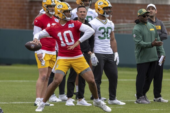 With Green Bay Packers head coach Matt LaFleur looking on quarterback Jordan Love (10) throws during an OTA practice Wednesday, May 28, 2025, in Green Bay, Wis. (AP Photo/Mike Roemer)