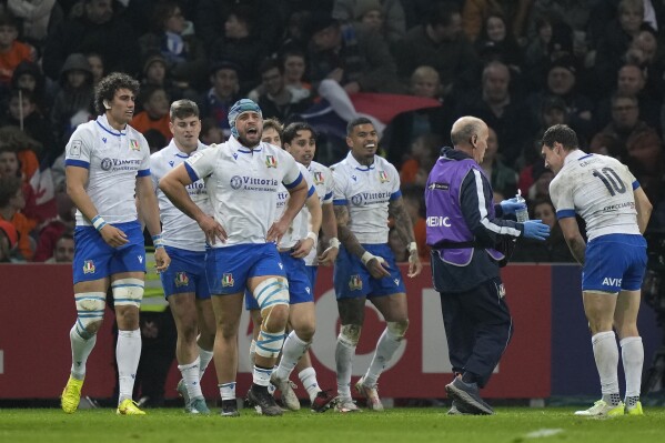 Italy players celebrate after Italy's Ange Capuozzo scored a try during the Six Nations rugby union international between France and Italy at the Pierre Mauroy stadium in Villeneuve d'Ascq, northern France, Sunday, Feb. 25, 2024. (AP Photo/Lewis Joly)