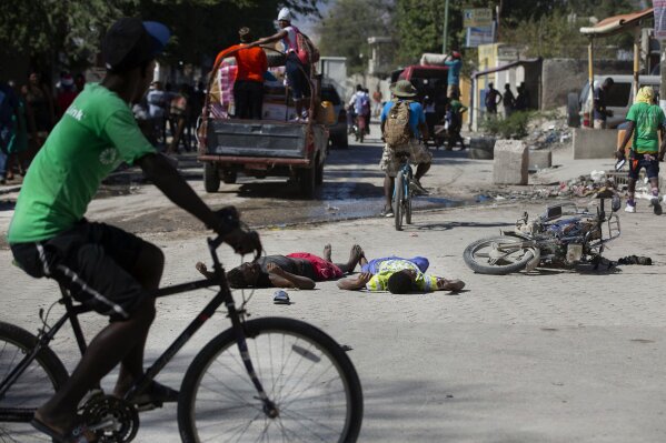 The bodies of two inmates lie on the street outside the Croix-des-Bouquets Civil Prison after an attempted breakout, in Port-au-Prince, Haiti, Thursday, Feb. 25, 2021. At least seven people were killed and one injured after eyewitnesses told The Associated Press that several inmates tried to escape from the prison in Haiti’s capital. (AP Photo/Dieu Nalio Chery)