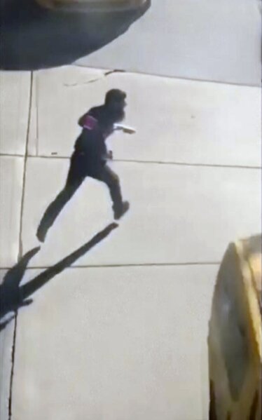This image made from a video provided by Tawhid Kabir shows the suspect in a deadly attack running across the street with a fake gun in each hand on Tuesday, Oct. 31, 2017, in New York. The man mowed down pedestrians and cyclists along a busy bike path near the World Trade Center memorial on Tuesday, before he was shot in the abdomen by police after jumping out of the truck, authorities said. (YouTube/Tawhid Kabir via AP)