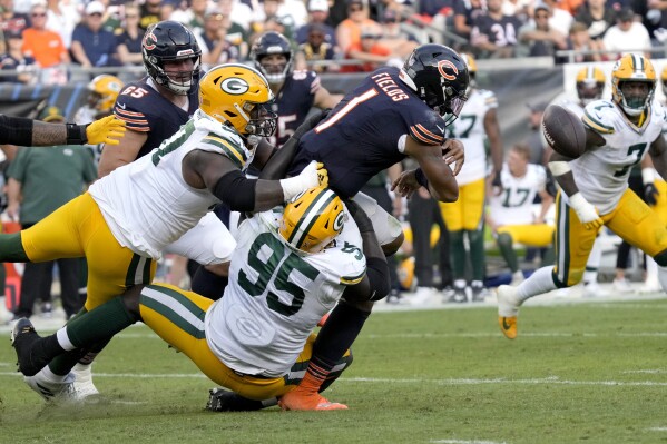 Green Bay Packers defensive tackle Kenny Clark, left, and defensive tackle Devonte Wyatt (95) create a sack fumble by Chicago Bears quarterback Justin Fields during the second half of an NFL football game Sunday, Sept. 10, 2023, in Chicago. (AP Photo/Nam Y. Huh)