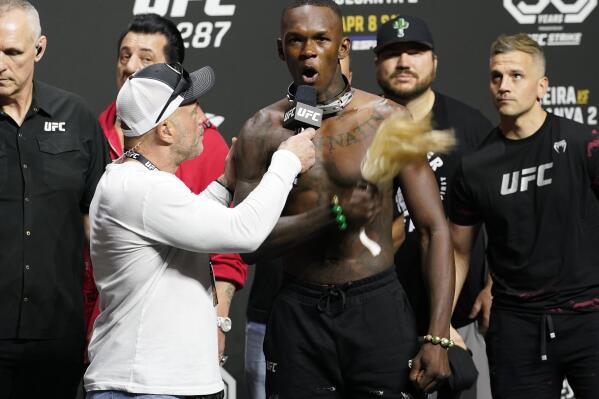 UFC commentator Joe Rogan, front left, listens to Israel Adesanya after a ceremonial weigh-in Friday, April 7, 2023, in Miami. Adesanya will face UFC 287 middleweight champion Alex Pereira on Saturday. (AP Photo/Marta Lavandier)