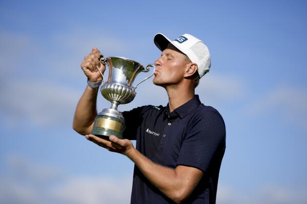 Adrian Meronk kisses the trophy after winning the final round of the Italian Open golf tournament in Guidonia Montecelio, Sunday, May 7, 2023. The Marco Simone club outside Rome will host the Ryder Cup later this year. (AP Photo/Andrew Medichini)