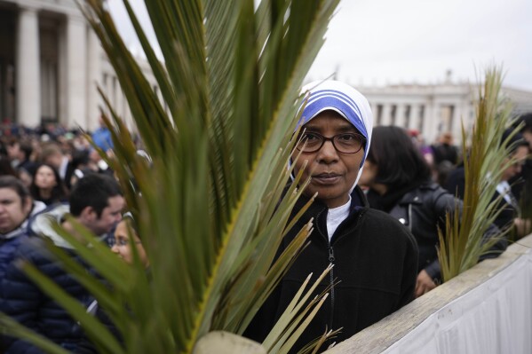 Faithful hold palm branches prior to the start of the Palm Sunday mass in St. Peter's Square at the Vatican, Sunday, March 24, 2024. (AP Photo/Alessandra Tarantino)