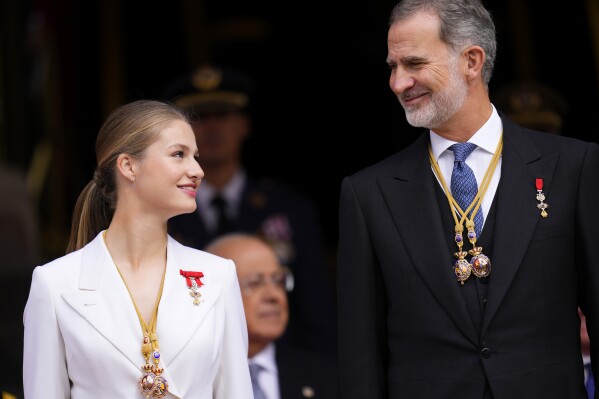 Princess Leonor looks at her father, the Spanish King Felipe VI, as they attend a military parade after swearing allegiance to the Constitution during a gala event that makes her eligible to be queen one day, in Madrid on Tuesday, Oct. 31 2023. The heir to the Spanish throne, Princess Leonor has sworn allegiance to the Constitution on her 18th birthday. Tuesday's gala event paves the way to her becoming queen when the time comes. Leonor is the eldest daughter of King Felipe and Queen Letizia. (AP Photo/Manu Fernandez)