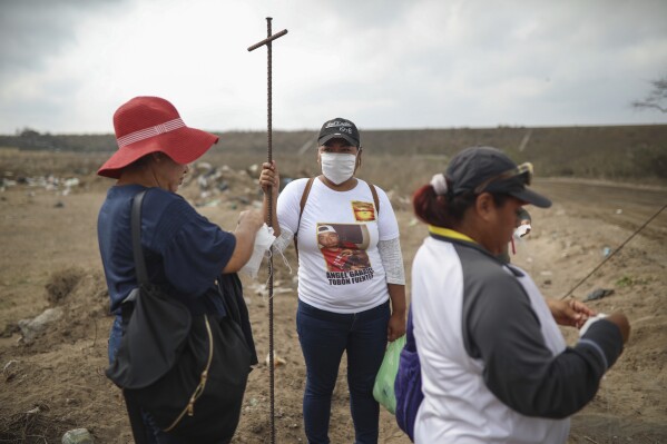 FILE - Lidia Lara Tobon, center, whose brother Angel Gabriel Tobon went missing, works with other relatives of the disappeared from the Solecito Collective, as they search for clandestine graves inside a municipal dump in the port city of Veracruz, Mexico, Monday, March 11, 2019. The Mexican government's 2023 bid to detect 'fake' missing people, those who have returned home but not notified authorities, has sparked anger among the families of Mexico's estimated 113,000 'disappeared.' (AP Photo/Felix Marquez, File)