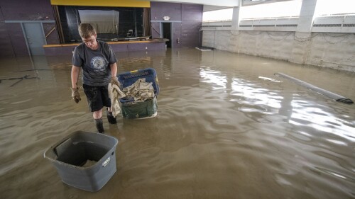 Congregation member Gayle McFarland, of Montpelier, Vt., collects sodden table cloths in the basement of Bethany Church, in downtown Montpelier, Thursday, July 13, 2023. In Vermont, communities were cleaning up Thursday from the floods that were more destructive in some places than 2011's Tropical Storm Irene. (Jeb Wallace-Brodeur/The Times Argus via AP)