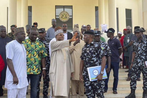 Kaduna state governor Uba Sani, centre, gestures after a meeting with security officers in Kaduna, Nigeria, Sunday, March 24, 2024. Officials in Nigeria say over 130 of nearly 300 schoolchildren have been released more than two weeks after they were seized in the northwestern state of Kaduna and marched into the forests. Sani, who first announced the rescue, did not give details about the operation. (AP Photo/Chinedu Asadu)