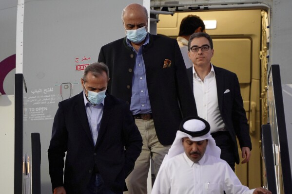 From left, Emad Sharghi, Morad Tahbaz and Siamak Namazi, former prisoners in Iran, walk out of a Qatar Airways flight that brought them out of Tehran and to Doha, Qatar, Monday, Sept. 18, 2023. Five prisoners sought by the U.S. in a swap with Iran were freed Monday and headed home as part of a deal that saw nearly $6 billion in Iranian assets unfrozen. (AP Photo/Lujain Jo)