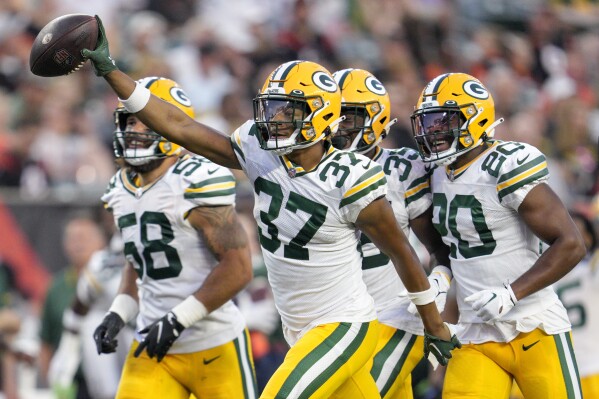 FILE - Green Bay Packers cornerback Carrington Valentine (37) celebrates with teammates after making an interception during a preseason NFL football game against the Cincinnati Bengals Friday, Aug. 11, 2023, in Cincinnati. The trade of Rasul Douglas to the Buffalo Bills this week while 2021 first-round draft pick Eric Stokes remains on injured reserve, likely creates more opportunities for rookie seventh-round pick Valentine and 27-year-old Corey Ballentine, who was signed off the practice squad last week. (AP Photo/Jeff Dean, File)