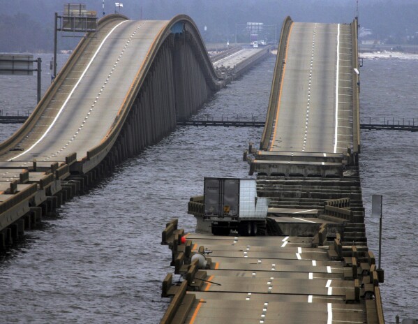 FILE - A tractor trailor rests on a section of I-10 bridge that crosses Escambia Bay, in Pensacola, Fla., Sept. 16, 2004, that was washed and damaged by Hurricane Ivan. (AP Photo/Eric Gay, File)