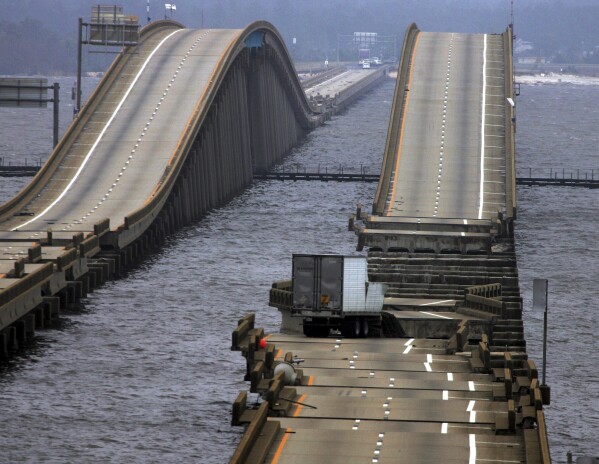 FILE - A tractor trailor rests on a section of I-10 bridge that crosses Escambia Bay, in Pensacola, Fla., Sept. 16, 2004, that was washed and damaged by Hurricane Ivan. (AP Photo/Eric Gay, File)