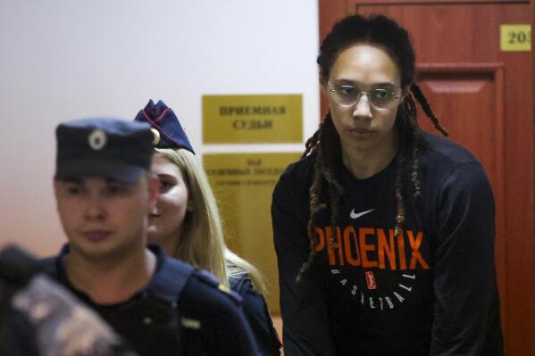 WNBA star and two-time Olympic gold medalist Brittney Griner is escorted to a courtroom for a hearing, in Khimki just outside Moscow, Russia, Wednesday, July 27, 2022. American basketball star Brittney Griner returned Wednesday to a Russian courtroom for her drawn-out trial on drug charges that could bring her 10 years in prison of convicted. (Evgenia Novozhenina/Pool Photo via AP)
