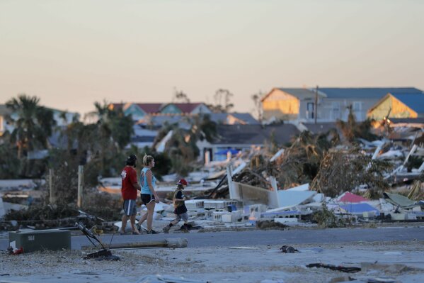 
              People walk amidst rubble in the aftermath of Hurricane Michael in Mexico Beach, Fla., Saturday, Oct. 13, 2018. (AP Photo/Gerald Herbert)
            