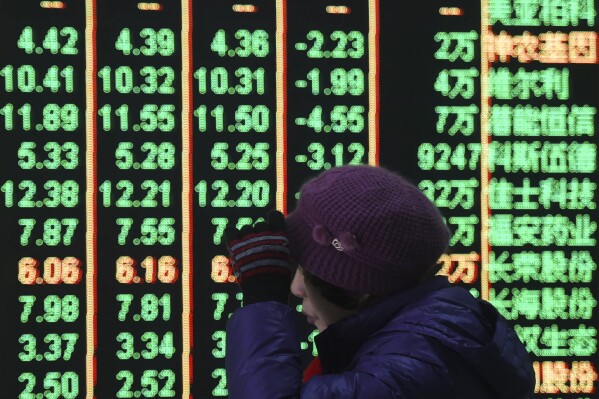 FILE - A woman reacts in front of an electronic screen displaying stock prices at a brokerage house in Hangzhou in east China's Zhejiang province, on Feb. 5, 2024. Chinese shares rallied on Friday, March 8, 2024, following better-than-expected import and export data, signaling increased demand that could support Beijing's effort to rev up the economy. (Chinatopix via AP, File)