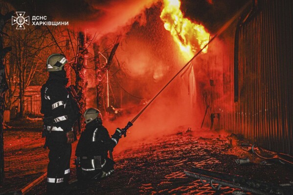 In this photo provided by the Ukrainian Emergency Service, firefighters put out the fire following a Russian attack in Kharkiv, Ukraine, Thursday, March 27, 2025. (Ukrainian Emergency Service via AP)