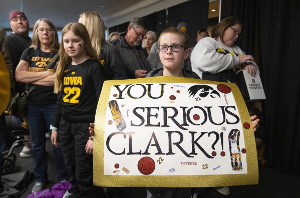 Brantlee Grant, 8, from Russell, Minn. holds up a homemade sign in support of Iowa's standout women's basketball player, Caitlin Clark, while waiting in line to enter before the NCAA college basketball game between Iowa and Penn State in the quarterfinals of the Big Ten women's tournament Friday, March 8, 2024, in Minneapolis. (Alex Kormann/Star Tribune via AP)