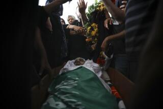 Palestinian mourners gather around the body of Mohammad Kiwan, 17, whose family says he was killed in clashes with Israeli police in the Arab town of Umm al-Fahm, Thursday, May 20, 2021. Police say the May 12 shooting is under investigation. (AP Photo/Mahmoud Illean)