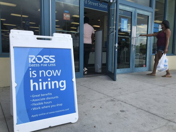 FILE - In this July 8, 2020, file photo, a "Now Hiring" sign sits outside a Ross Dress for Less store, in North Miami Beach, Fla. The United States added 1.8 million jobs in July, a pullback from the gains of May and June and evidence that the resurgent coronavirus has weakened hiring and the economic rebound. (AP Photo/Wilfredo Lee, File)