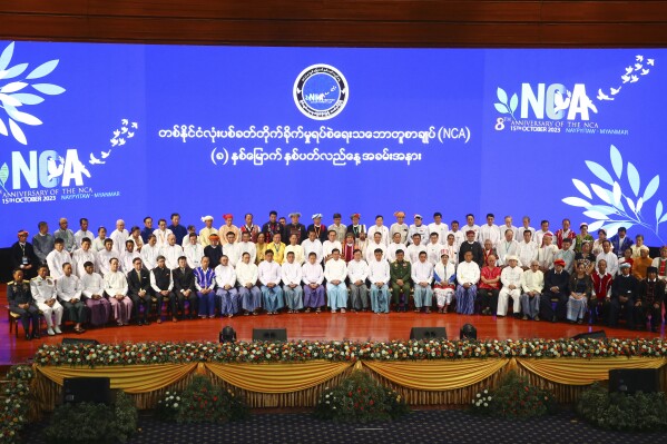 Senior Gen. Min Aung Hlaing, head of the military council, center in the first row, and Deputy chairman of State Administration Council, Vice Senior Gen. Soe Win, center left in the first row, and other attendees sit for a group photo after a ceremony to mark the 8th anniversary of the Nationwide Ceasefire Agreement (NCA) at the Myanmar International Convention Center in Naypyitaw, Myanmar, Sunday, Oct. 15, 2023. (AP Photo/Aung Shine Oo)