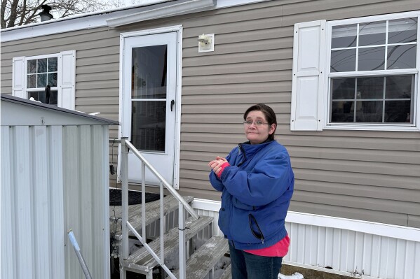 Amy Case stands in her mobile home park Tuesday, Jan. 23, 2024, in Auburn Mass. where residents complain they are facing double-digit rent increases that they cannot afford. Their concerns are echoed nationally where a report from Harvard University found 22.4 million renter households are rent burdened. Monthly rent has outpaced income across the U.S., and forced many to make tough decisions between everyday necessities and a home. In turn, a record number of people are becoming homeless and evictions filings have ratcheted up as pandemic-era eviction moratoriums and federal assistance ends. (APPhoto/Michael Casey)