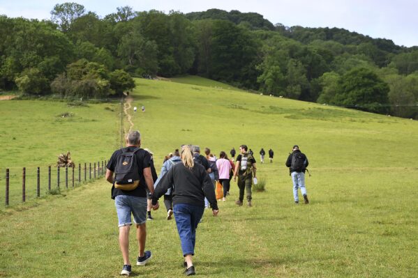 Spectators walk up Cooper's Hill to watch the traditional annual Cheese Rolling contest at in Brockworth, Gloucestershire, England, Monday, May 26, 2025.(AP Photo/Anthony Upton)