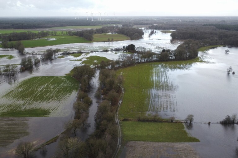 The small river Hunte has burst its banks near Oldenburg and is flooding the surrounding meadows and fields in Huntlosen, Germany, Wednesday, Jan. 3, 2024. (Christian Charisius/dpa via AP)