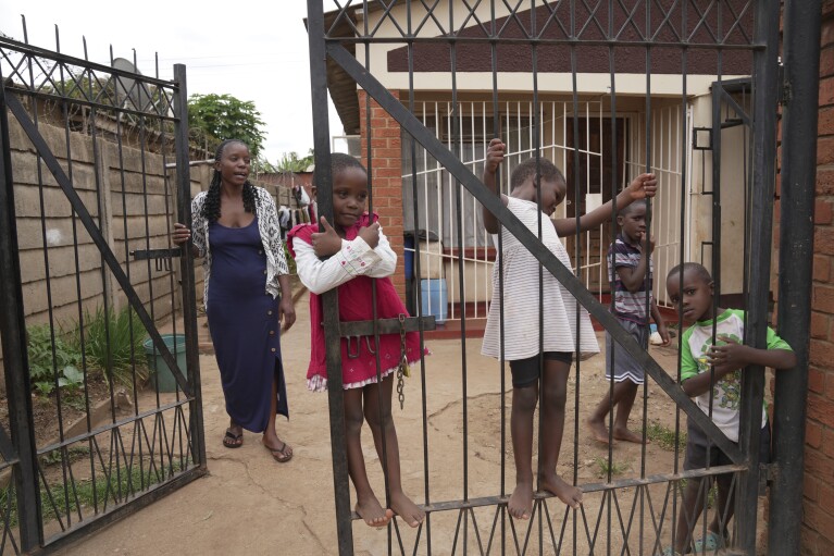 Children survivors of cholera play on a gate on the outskirts of Harare, Zimbabwe, Saturday, March 2, 2024. (AP Photo/Tsvangirayi Mukwazhi)