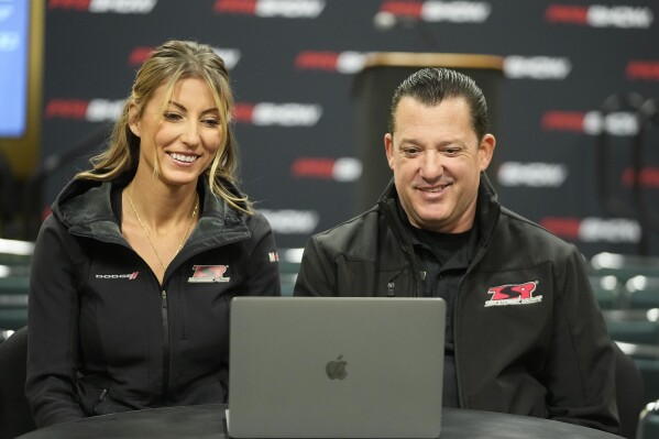 Leah Pruett and her husband Tony Stewart speak during a news conference, Thursday, Dec. 7, 2023, in Indianapolis. Pruett will step away from the NHRA drag racing series in 2024 to focus on starting a family with Stewart. Her NASCAR Hall of Famer husband will replace her next season in the Top Fuel dragster. (AP Photo/Darron Cummings)