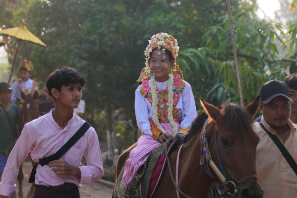 Would-be Buddhist novices ride on horses during a processional parade as part of a celebration of a novitiation or “Shinbyu,” ceremony, Saturday, March 15, 2025, at Hlegu township, outside of Yangon, Myanmar. (AP Photo/Thein Zaw)