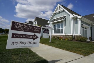 An open house is posted in front of a home for sale in Westfield, Ind., Friday, Sept. 25, 2020. The market for existing homes cooled slightly in November, the National Association of Realtors said Tuesday, Dec. 22, 2020 after climbing through the late spring, summer and early fall despite the pandemic. (AP Photo/Michael Conroy)