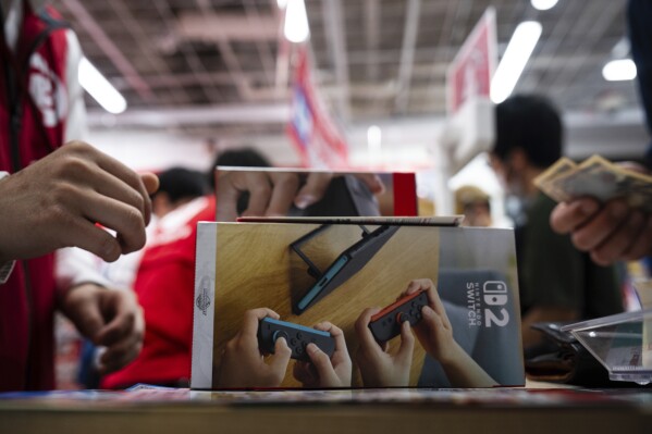 A customer purchases Nintendo Switch 2 at an electronics retailer in Tokyo, Thursday, June 5, 2025. (AP Photo/Louise Delmotte)