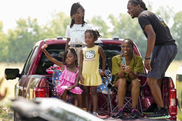 Reece Bratton, from left, Jordan Bratton and Nia Bratton and their parents, Faith and Kevin Bratton, watch Katy's first Juneteenth parade, Monday, June 19, 2023, in Katy, Texas. (Yi-Chin Lee/Houston Chronicle via AP)